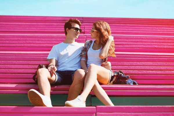 夏甘いです若いです愛するカップルティーンエイジャー見ますお互い上のピンクのベンチに都市公園屋外で ストック写真