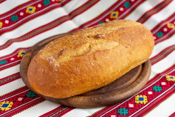 Čerstvý bílý chléb na hnědé dřevěné řezací desce — Stock fotografie