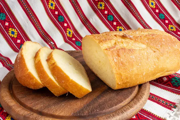 Φρέσκο λευκό ψωμί σε καφέ ξύλο κοπής σκάφους με φέτες ψωμιού — Φωτογραφία Αρχείου