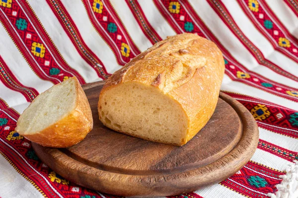 Φρέσκο λευκό ψωμί σε καφέ ξύλο κοπής σκάφους με φέτες ψωμιού — Φωτογραφία Αρχείου