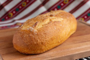 Kahverengi ahşap kesme tahtasında taze beyaz ekmek