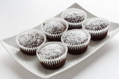 Beyaz kare tabakta birkaç çikolatalı kek. Sığ odak.