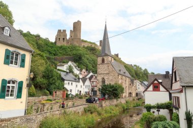 Loewenburg şatosunun harabeleri ile Panorama Monreal 'in Eifel köyünün yukarısında yarım kereste evler ve Almanya' nın Elsbach nehri üzerinde bir çıkıntı.