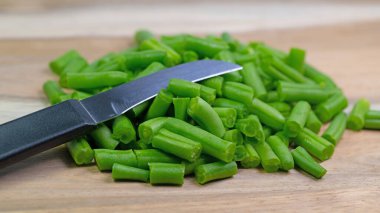 Dilimlenmiş yeşil fasulye ve mutfak bıçağı.