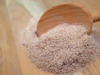 Buğday kepeği ve tahta kaşık yakın planda.