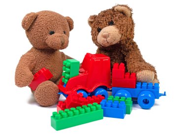 Beyaz arka planda pelüş ayılar ve plastik yapı taşları