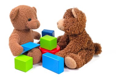 Beyaz arka planda pelüş ayılar ve ahşap yapı taşları