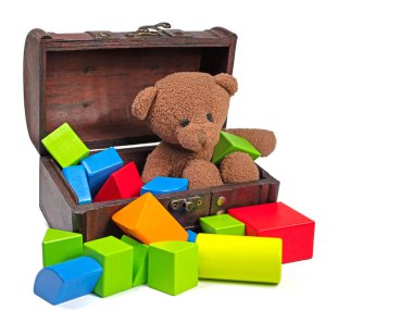 Beyaz arka plana karşı pelüş ayı ve ahşap yapı taşları