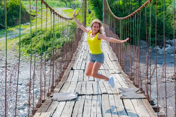 one person jumping on a suspension bridge in Georgia. High quality photo