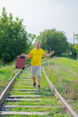 bavullu gizemli turist demiryolunda yürüyor.