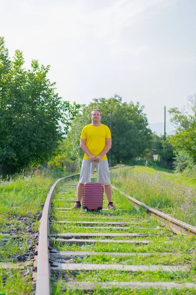 Fiú sétál a vasúton egy bőrönddel — Stock Fotó