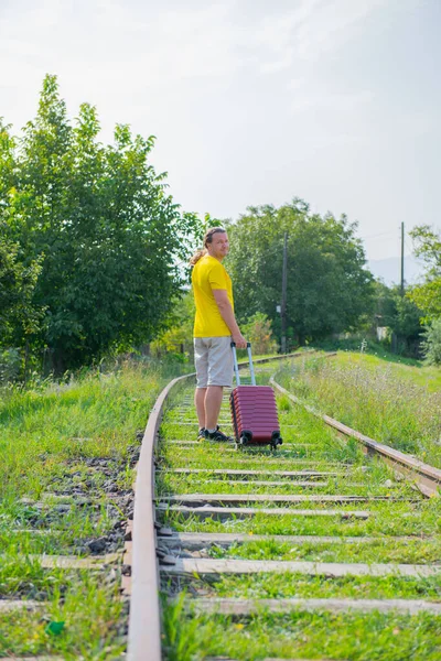 Sarı Tişörtlü Bir Adam Elinde Bavulla Demiryolunda Yürüyor Yüksek Kalite — Stok fotoğraf