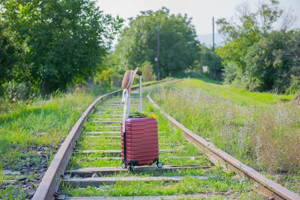 Egy Piros Bőröndöt Egy Kalapot Vasúti Állványokon Kiváló Minőségű Fénykép — Stock Fotó