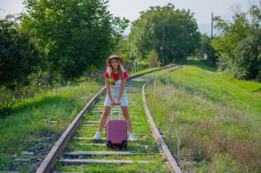 Mutlu gezgin patika boyunca bir bavulla yürür. Yüksek kalite fotoğraf