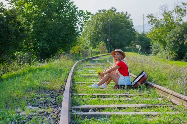 Yorgun gezgin bir bavulun içinde demiryolunda oturuyor. Yüksek kalite fotoğraf