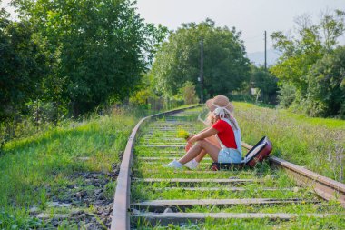 Gezgin, demiryolunda bir bavulun içinde oturur. Yüksek kalite fotoğraf