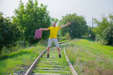 Elinde bavuluyla demiryoluna atlayan bir adam. Yüksek kalite fotoğraf
