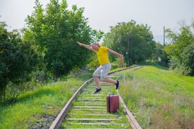 Demiryolunda kırmızı bavullu atlayan adam. Yüksek kalite fotoğraf