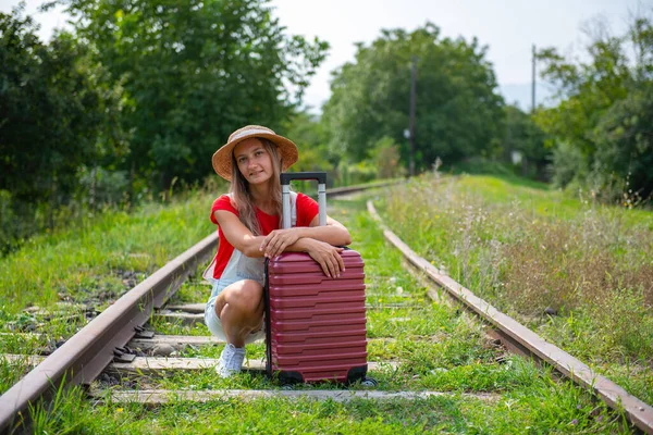 Güzel gezgin demiryolunda bir bavula sarılıyor. — Stok fotoğraf