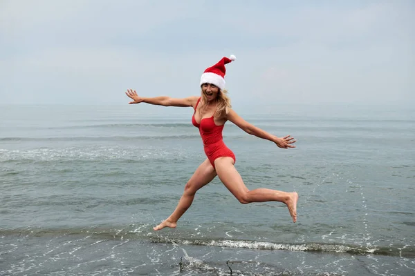 Vacker flicka i en röd baddräkt på havet stranden — Stockfoto