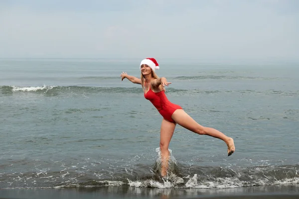 Bella ragazza in costume da bagno rosso sulla spiaggia del mare — Foto Stock