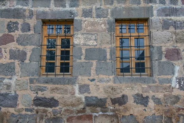 不同质地的石墙，有窗户和栅栏 — 图库照片
