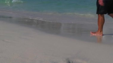 Sahil boyunca hareket eden bacakların görüntüsü, yakın plan