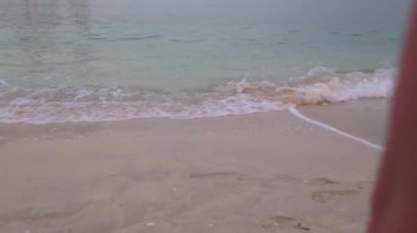 Sahil boyunca hareket eden bacakların görüntüsü, yakın plan