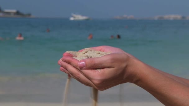 Sable déverse des mains sur la plage de la mer — Video