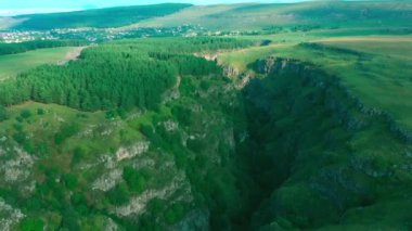 Dağlarda bir nehir ve ağaçla kanyon, geçitten çekiliyor.