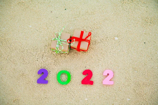 2022 номер лежить на піску поруч з подарунками — стокове фото