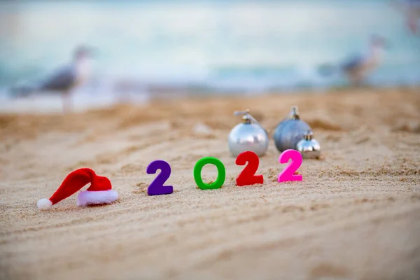 На піску 2022 і Санта капелюсі — стокове фото