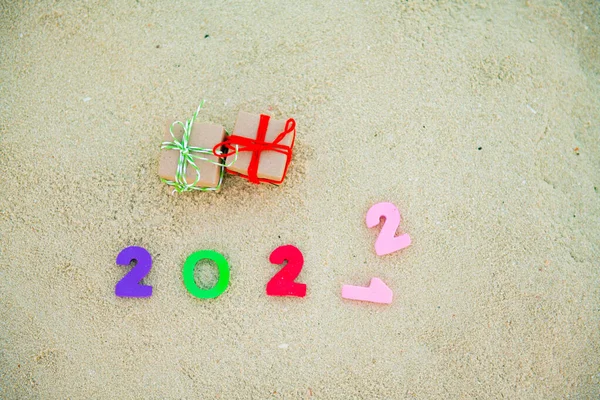 Gifts and colored numbers for the new year 2022 on the sand — Foto Stock