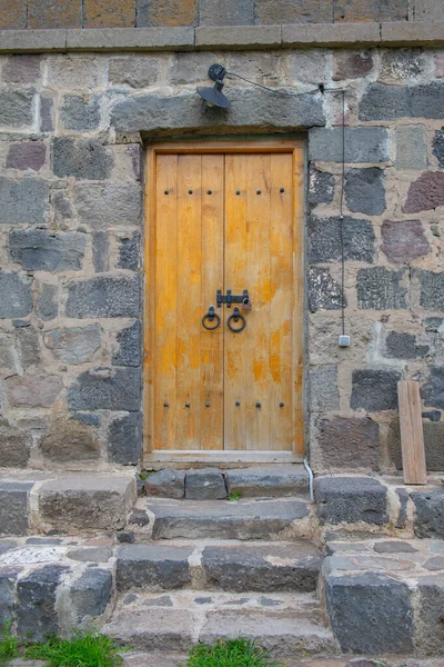 Pared de piedra de diferente textura con una puerta de madera —  Fotos de Stock