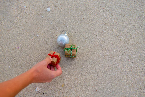 Presentes são colocados na areia e um brinquedo de Ano Novo — Fotografia de Stock