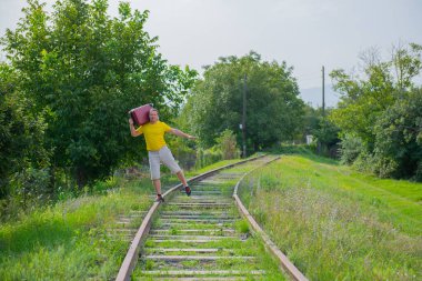 a dancing man in a yellow t-shirt runs on the rails
