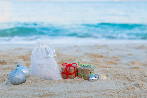Weihnachtstasche mit Geschenken am Strand — Stockfoto