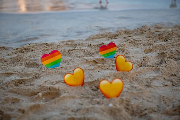 Lgbt ve sarı kalpler denizin üzerinde duruyor. — Stok fotoğraf