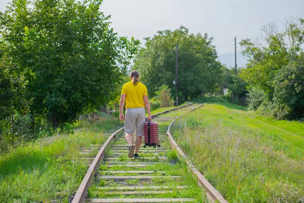 An old guy in a yellow t-shirt runs along the rails — Stock Photo, Image