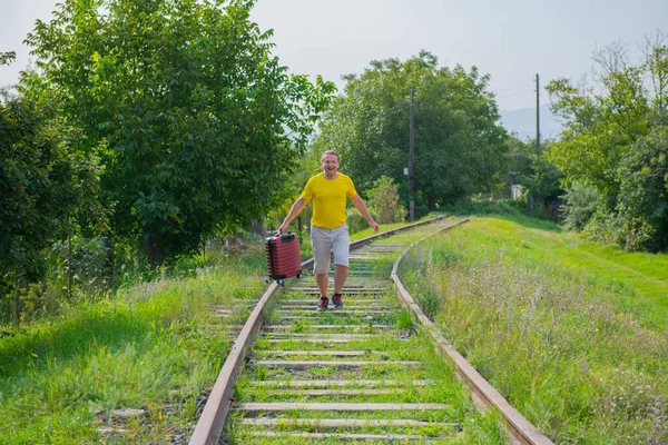 Egy sárga pólós fiatalember fut a síneken. — Stock Fotó