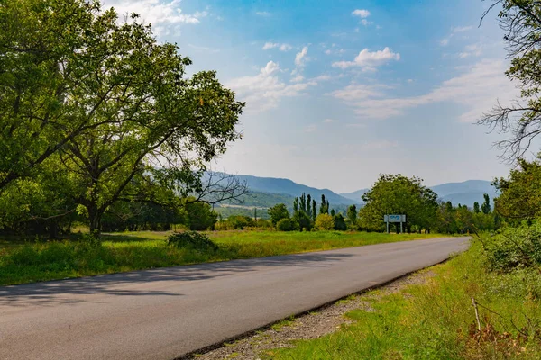 Dağlara doğru geniş asfalt bir yol var.