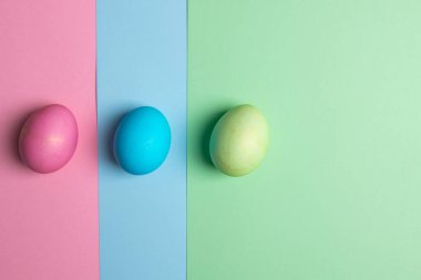 Üç renkli arka planda renkli yumurtalar var.