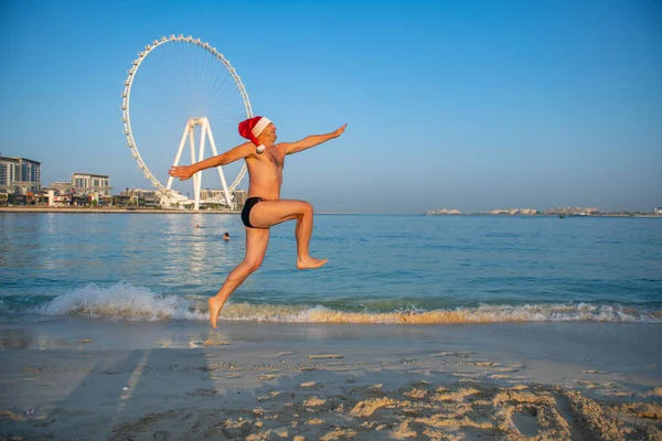 Un uomo che salta lungo la spiaggia sulla sabbia — Foto Stock