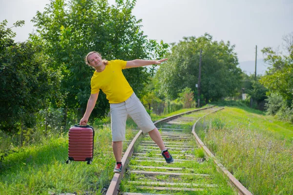 Raylarda bavulu olan yalnız bir yolcu gider. — Stok fotoğraf