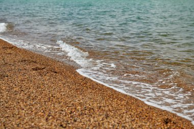 Sert kum ve dalgalarıyla kumlu sahil