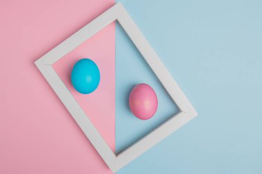 Beyaz çerçeveli mavi ve pembe paskalya yumurtaları