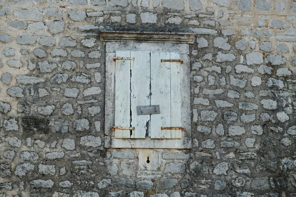 A parede de pedra é velha e a janela está fechada — Fotografia de Stock