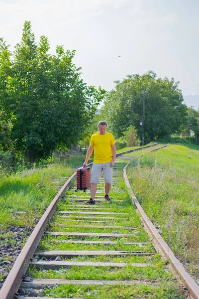 Egy bőröndös turista sétál a vasúton. — Stock Fotó