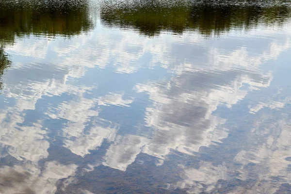 Odbicie w błękitnym jeziorze niebo z chmurami — Zdjęcie stockowe