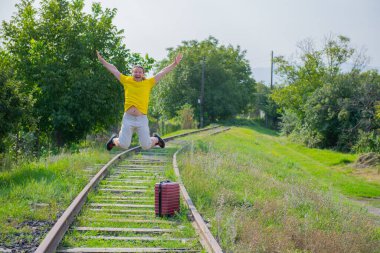 Elinde bavuluyla demiryoluna atlayan pervasız turist.